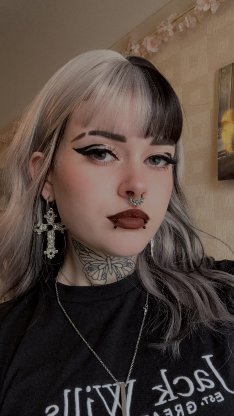 Sterling blonde with a mix of grey. A slice of jet black for added definition takes this style to the next level. Black tones come from the nape of the neck. Giving a peek-a-boo effect. Loose waves fall just past the shoulders, a blunt sleek fringe carries the split colour.