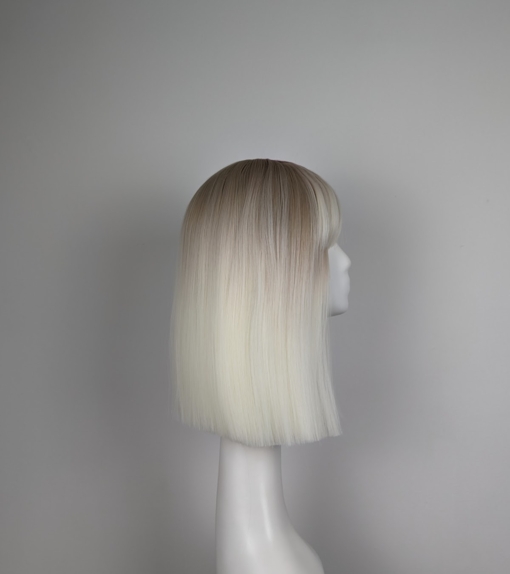 Lorna is a rework of the platinum blonde colour with a muted  lemon undertone. A sprinkle of sandy blonde roots, creating a natural feel. Poker straight, long one length bob (lob) with a sleek full fringe.