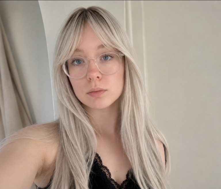 Maddy - Lush Wigs UK Dark brown shadowed roots blend into a sterling blonde colour. Cut into long straight layers to add fullness and movement. A blunt sleek fringe finishes the look.