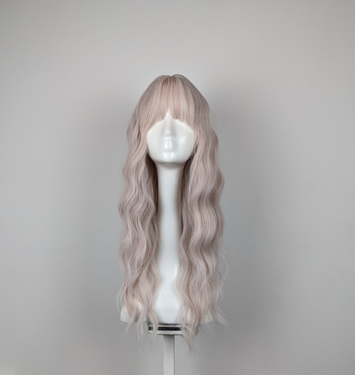 A platinum blonde with a twist of subtle baby pink running through the lengths from roots to tips. A loose barrel curl carries this style beautifully. Cut in layers to add various lengths to the look. A light fringe carries the colour.