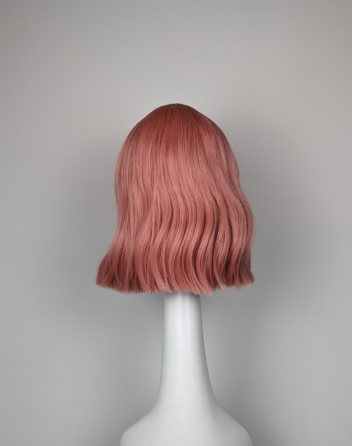 Peach bob with a sight wave. Creamy peach from roots to tips. A light fringe frames the face.