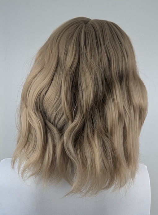 This bob is styled into loose tousled waves with plenty of volume. A light blonde shade from roots to tips. With a sleek blunt fringe 