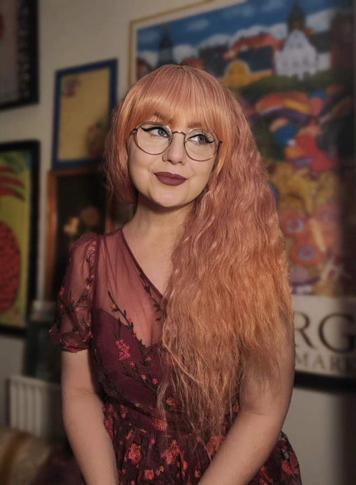 This wig is so fluffy, yet so lightweight and comfortable. A soft crimped style in a blend of coral pink that fades into a more warm-toned peach. The longer fringe allows the freedom to choose between straight across bangs or more of a side fringe. An absolute dream wig!