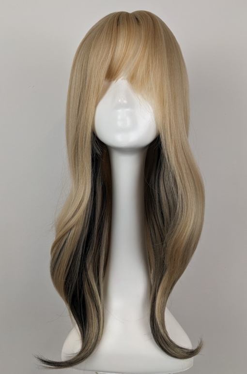 Sandy blonde with brown streaks coming from the nape of the neck, for a peek-a-boo effect with a full fringe. A Blow out style falls to the waist