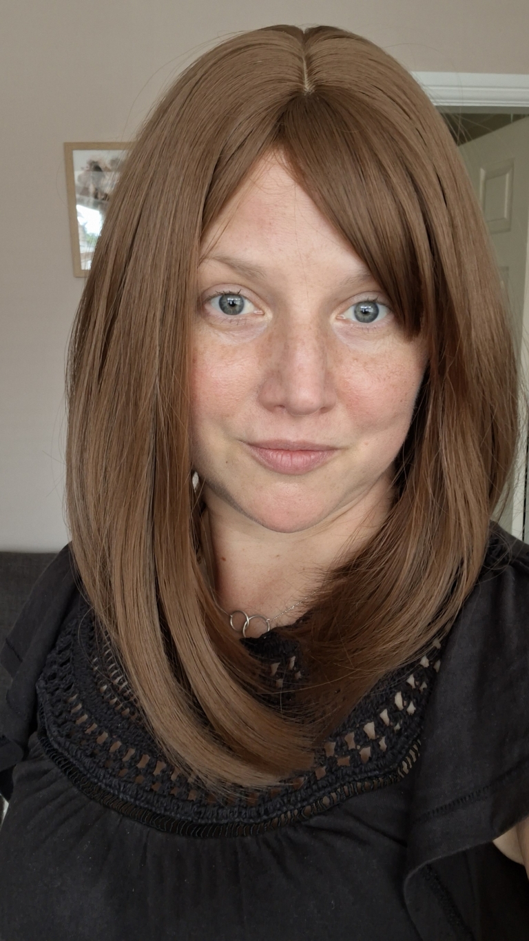 This natural brown colour wig is simple and easy to wear. Its rich brown shades come to life with golden-copper undertones. A sleek long bob (lob) that curls just under at the ends. With a light sleek fringe.