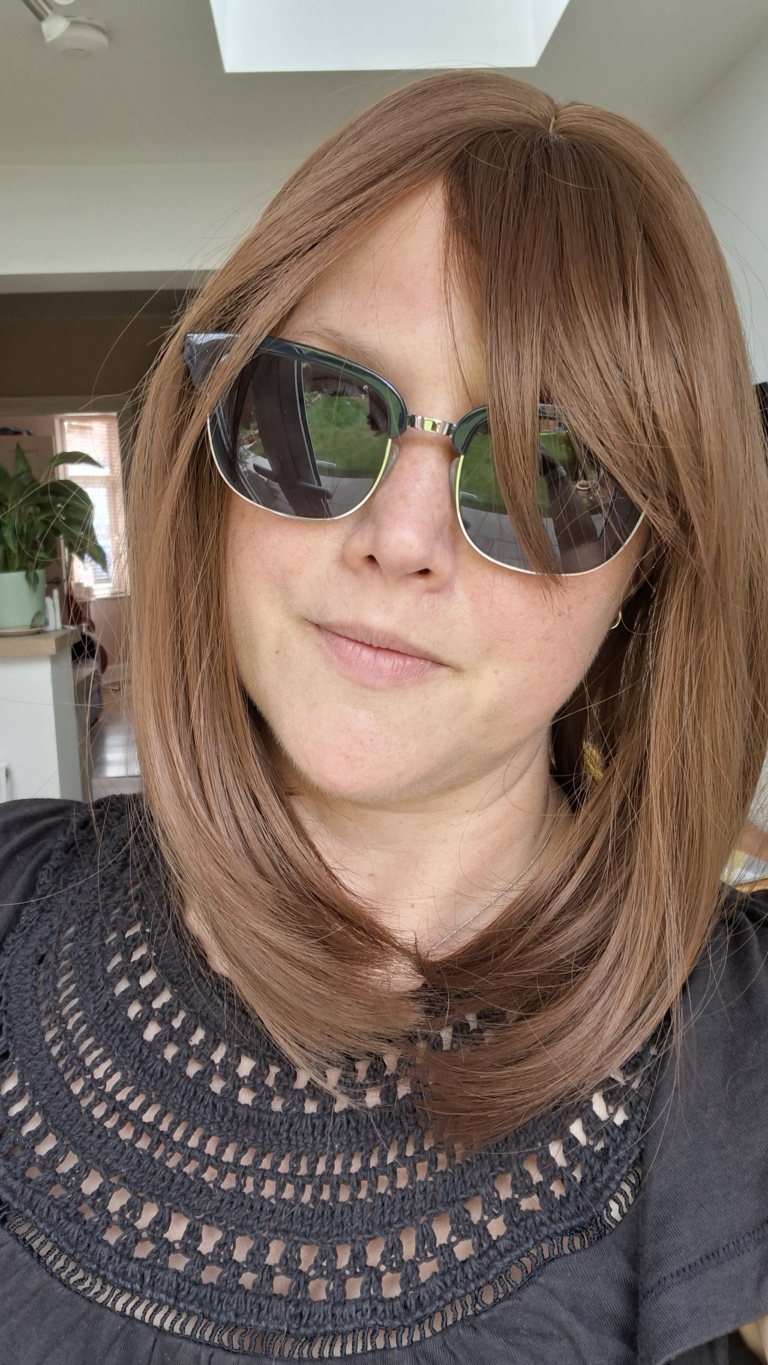 This natural brown colour wig is simple and easy to wear. Its rich brown shades come to life with golden-copper undertones. A sleek long bob (lob) that curls just under at the ends. With a light sleek fringe.