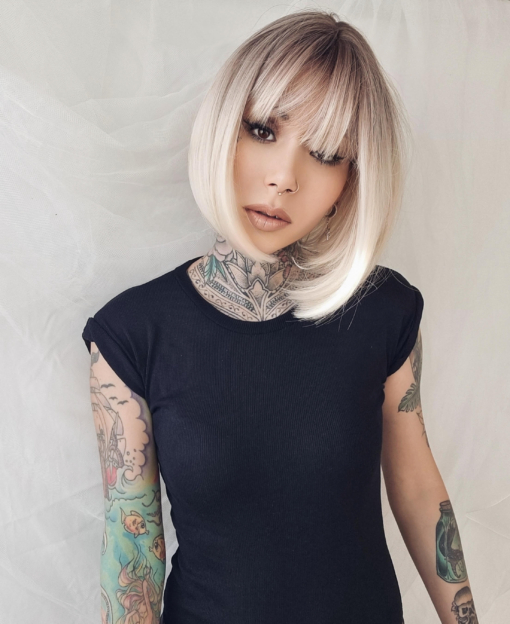 This natural bleach blonde wig is simple and chic. A sleek jaw skimming bob with a sprinkle of dark blonde roots that melt into the blonde hue. A light fringe finishes the look.