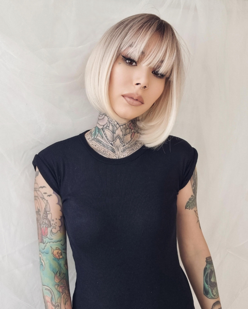 This natural bleach blonde wig is simple and chic. A sleek jaw skimming bob with a sprinkle of dark blonde roots that melt into the blonde hue. A light fringe finishes the look.