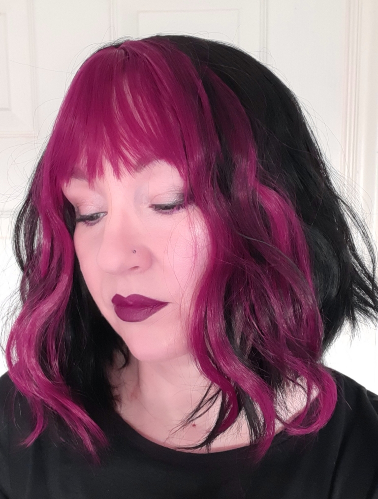 Myth - Lush Wigs UK This wavy bob comes to life with a face framing slice of bright purple colour. Thats carried into the sleek fringe and adds a peek-a-boo at the sides. A soft black colour from roots to tips.