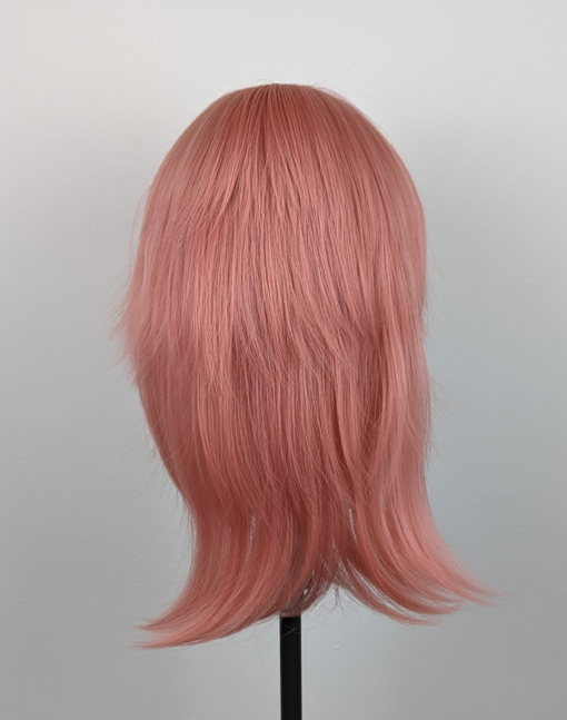 This glam rock throwback shaggy style has choppy layers on top. A soft peach tone from roots to tips. A lightweight easy style to wear.