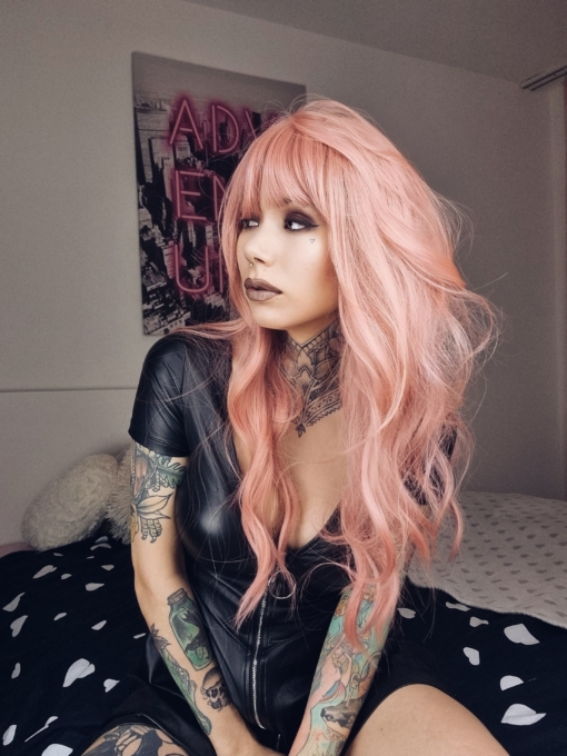 This delicious mix of pastel peach with subtle strands of pink create this creamy colour from roots to tips. The style is sleek from the roots that run into a waves throughout the layers. A light fringe frames the face.
