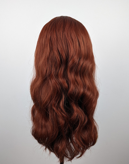 Relaxed tousled waves that fall to the waist. A rich vibrant dark auburn colour runs from roots to tips. A sleek airy fringe finishes the look.
