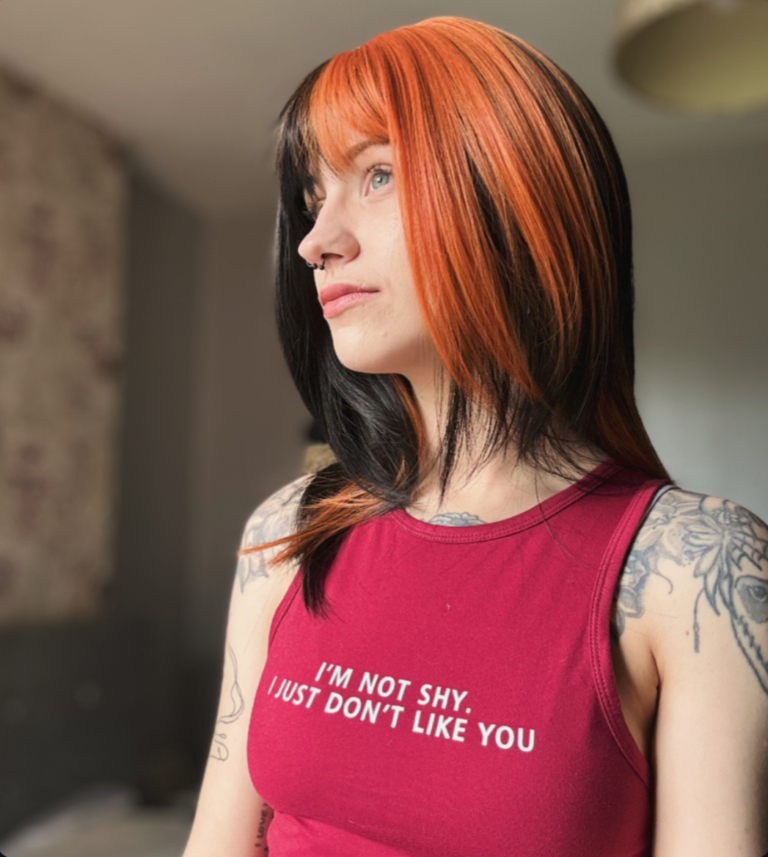 Blocks of burnt orange colour are carried through the black lengths of this sleek long bob. Sleek and choppy with lots of layers. The orange colour is carried into the fringe and on top of the head. Lots of orange undertones for a peek-a-boo effect.