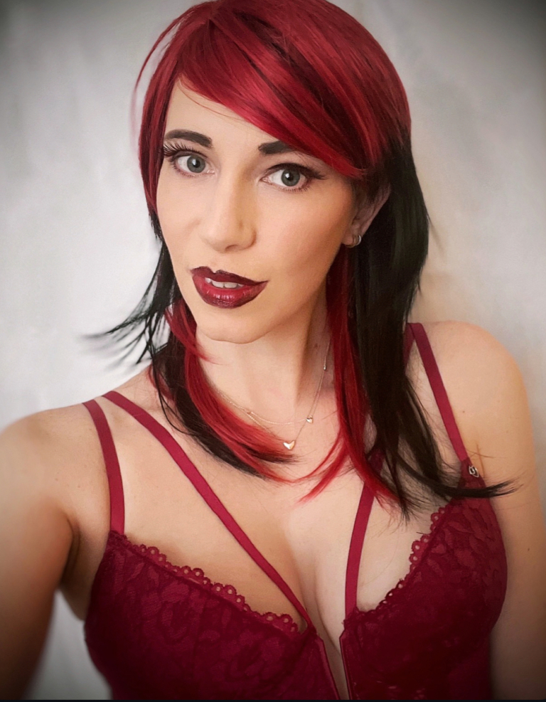 This glam rock throwback shaggy cut sleek style has red roots and a full red fringe. Cool black tone with a peek a boo red from the nape of the neck.