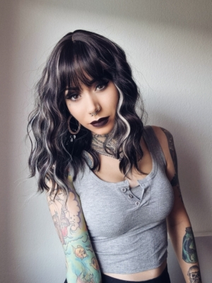 This long bob wig is styled into a loose wave. With a sleek blunt fringe. A very dark brown colour, defined with platinum blonde high-lights.  