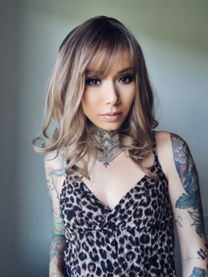 This natural wigs has warn brown shadowed that blend into a mix of hazel and dark blonde hues. Styled sleek with curls at the ends, a light fringe frames the face.