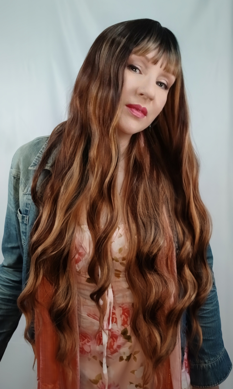 Addison - Lush Wigs UK A natural very long wig styled into loose waves throughout, with a sleek blunt fringe. Dark brown shadowed roots blend into a warm brown with high-lights to create this golden brown colour.