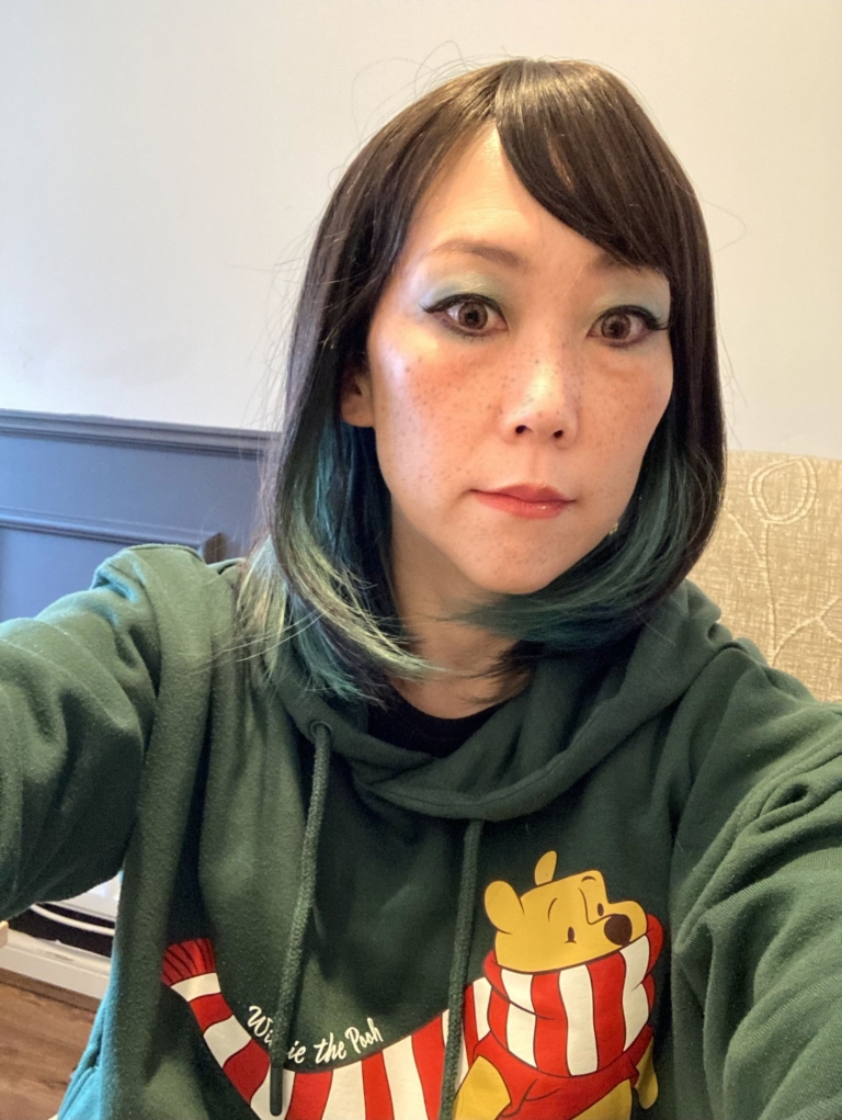 This dark brown and sage green wig has the best of both worlds. From the roots and fringe are a dark brown. Underneath lies a sage green for a peek-a-boo effect. Styled into a long sleek bob with layers for added volume.