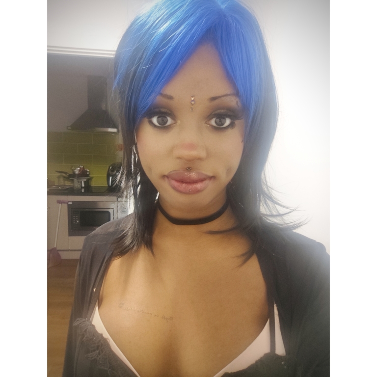 This glam rock throwback shaggy cut sleek style has blue roots and a full blue fringe. Cool black tone with a peek a boo of blue from the nape of the neck.