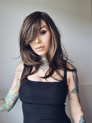 This natural wig has a mix of a deep brown colour blended with warm blonde lowlights. Styled sleek with long layers and a full fringe. Easy to wear and maintain.