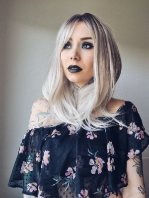 A wig with a mix of dark brown shadow roots that blend into a icy platinum blonde colour. The style is long and sleek with layers. Finished with a blow out turn at the ends.
A long sleek fringe can be parted into curtain bangs or swept to the side.