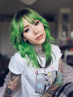 Green and bold. Dark brown roots blend into this bright two tone green colour, with a slice of dark brown at the nape of the neck. For a peek-a-boo effect. Styled into a loose wave with a blunt fringe.