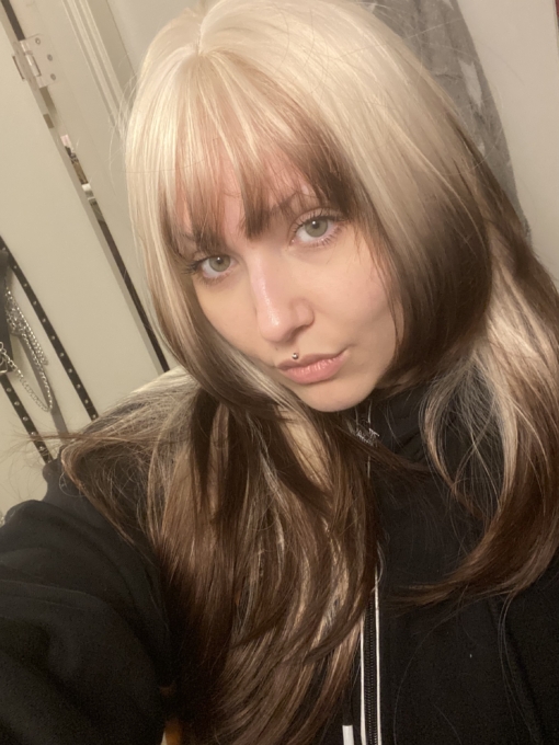 This natural wig comes in a mix of light blonde roots. They blend into a warm brown hue for a dip dye effect on the ends. A sleek long style with long layers at the back, face framing layers at the front make this style easy to maintain. With a sleek blunt fringe finishes the look.