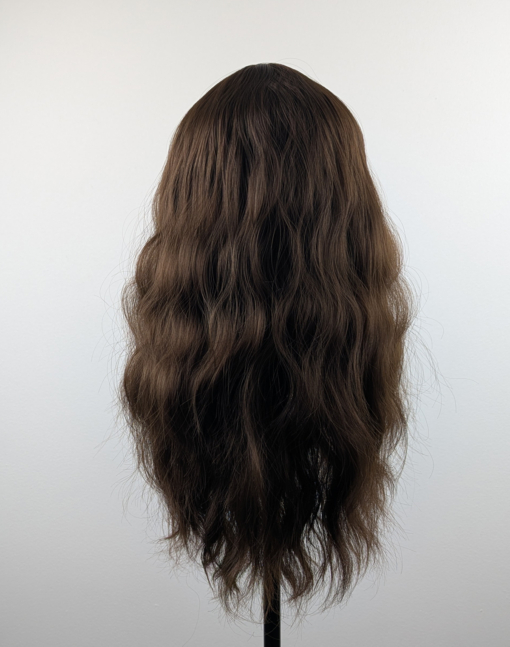 A natural brown chestnut shade from roots to tips with textured, tousled, loose waves. With a sleek blunt fringe.