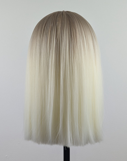 Outlet #147 - Lush Wigs UK A platinum blonde colour with a muted lemon undertone, producing a bleach blonde effect. A sprinkle of sandy blonde roots, creating a natural feel. Poker straight, long one length bob (lob) with a sleek full blunt fringe.