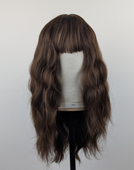A natural brown chestnut shade from roots to tips with textured, tousled, loose waves. With a sleek blunt fringe.