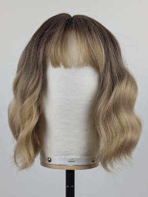Outlet #151 - Lush Wigs UK This bob is coloured in a honey blonde tone with brown shadowed roots. That gives a natural feel to the look. A loose wave and a sleek fringe finishes the look.