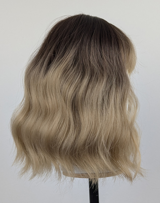 This bob is coloured in a honey blonde tone with brown shadowed roots. That gives a natural feel to the look. A loose wave and a sleek fringe finishes the look.