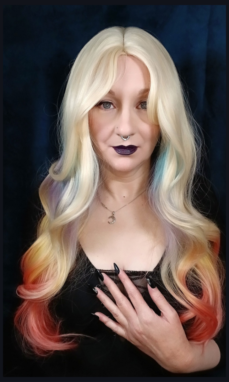 This multi-colour wig is a mixture of purple, blues, limes, greens and peach. From the nape of the neck giving a peek-a-boo effect. A natural blonde colour from the roots, thats carried into the sleek blunt fringe. Long and curly with invisible layers for bounce and volume.