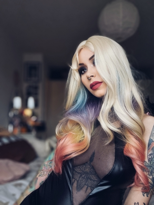 This multi-colour wig is a mixture of purple, blues, limes, greens and peach. From the nape of the neck giving a peek-a-boo effect. A natural blonde colour from the roots, thats carried into the sleek blunt fringe. Long and curly with invisible layers for bounce and volume.