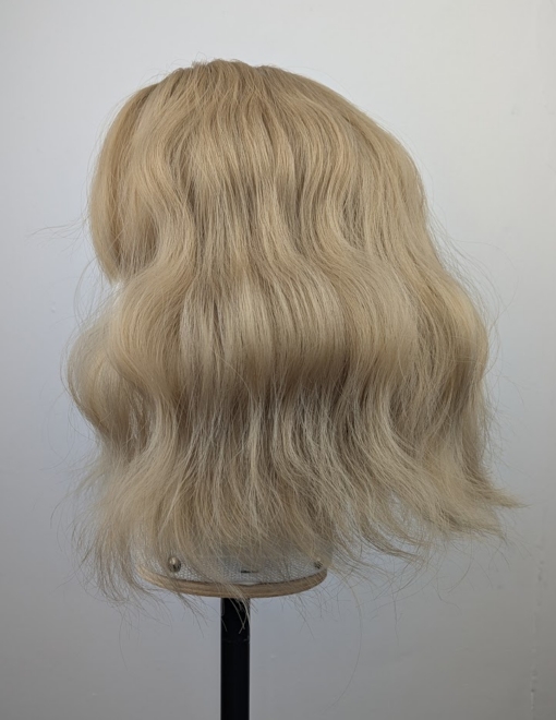 This bob has very loose tousled waves. A light blonde shade from roots to tips. With a sleek blunt fringe.