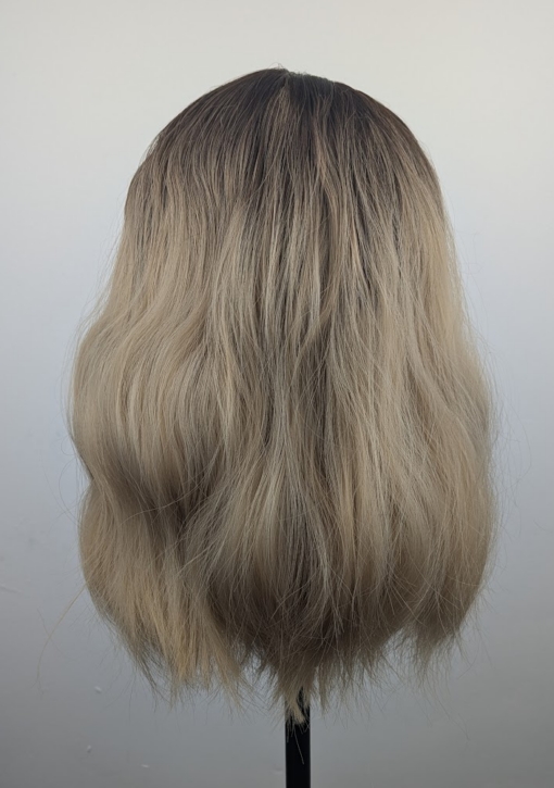 A long bob coloured in a honey blonde tone with brown shadowed roots for a completely natural feel. Finished with loose waves and a sleek fringe.
