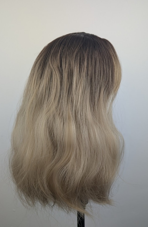 A long bob coloured in a honey blonde tone with brown shadowed roots for a completely natural feel. Finished with loose waves and a sleek fringe.