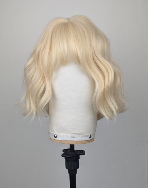 This natural bob comes in a light blonde tone from roots to tips. Styled into a loose flat iron effect wave, that's easy to wear and maintain. A sleek blunt fringe frames the face.