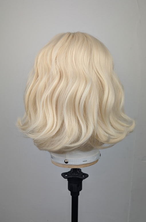 This natural bob comes in a light blonde tone from roots to tips. Styled into a loose flat iron effect wave, that's easy to wear and maintain. A sleek blunt fringe frames the face.