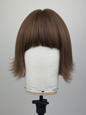This jaw-skimming bob, styled with a gentle flick curl at the ends. Short choppy layers add volume. With a sleek light fringe. A colour mix of warm light browns from roots to tips. Easy to wear and maintain.