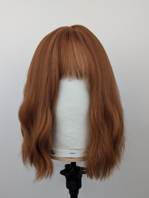 This relaxed wavy bob falls just above the shoulders. In a natural Warm apricot colour from root to tips. It’s sleek long fringe is versatile to be worn to suit your look.