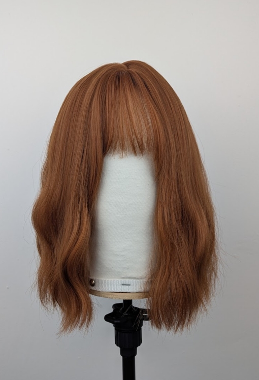 Outlet #226 - Lush Wigs UK This relaxed wavy bob falls just above the shoulders. In a natural Warm apricot colour from root to tips. It’s sleek long fringe is versatile to be worn to suit your look.