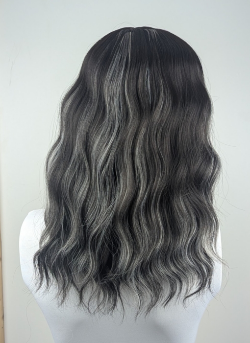 This long bob wig is styled into a loose wave. With a sleek blunt fringe. A very dark brown colour, defined with platinum blonde high-lights.  