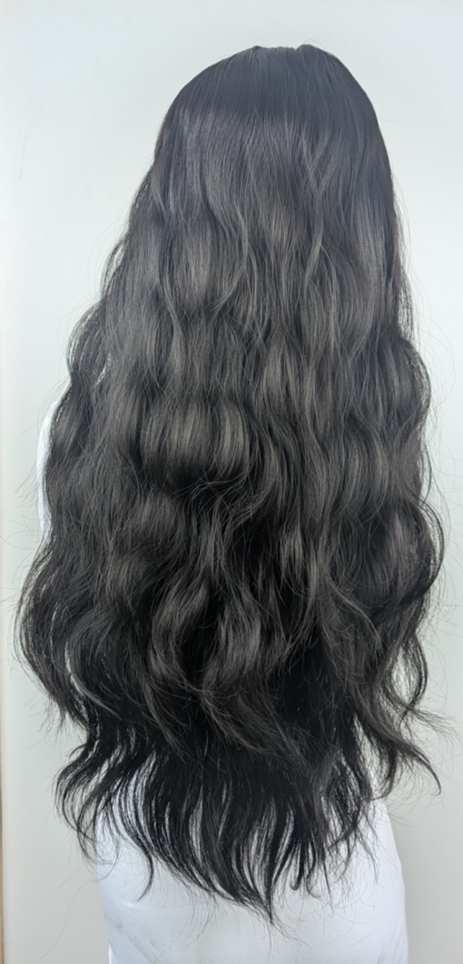 A very dark brown colour from roots to tips. Styled in loose waves that fall to the waist. Long invisible layers to add body and movement to the look. With a sleek blunt fringe.