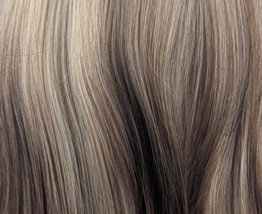 This Reverse Ombré natural wig has brown roots that blend into a sandy blonde, with warm russet brown ends. Styled sleek and choppy. The fringe is sleek and blunt and can be worn as curtain bangs.