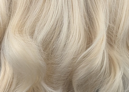 Waikiki - Lush Wigs UK This wig has a light golden blonde colour from roots to tips. It's styled sleek with large blow out curls at the ends for volume. A sleek blunt fringe frames the face.