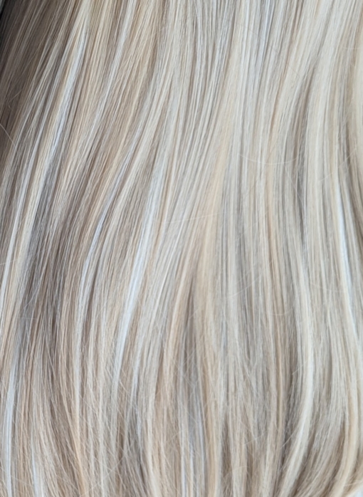 Ava - Lush Wigs UK A long and sleek wig with natural dark brown shadowed roots. They blend into a honey blonde with sterling blonde highlights. Styled into sleek long layers and a long fringe that can swept to the side or parted into curtain bangs.