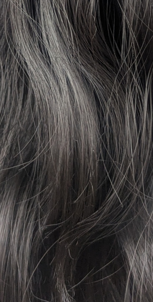 A very dark brown colour from roots to tips. Styled in loose waves that fall to the waist. Long invisible layers to add body and movement to the look. With a sleek blunt fringe.