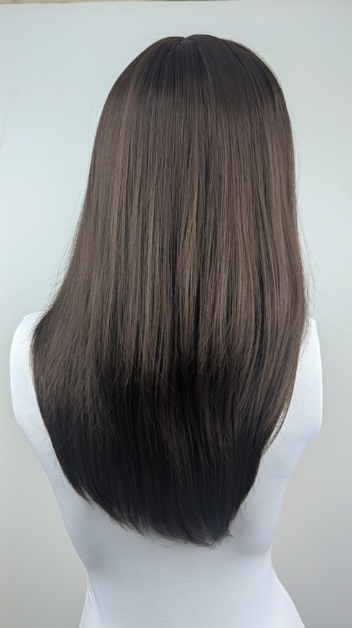 A sleek straight style in a natural chestnut colour. With long layers cut in and a blow out style to add fullness and movement. With a sleek blunt fringe.