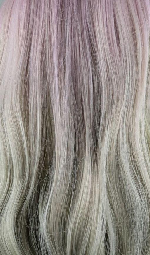 A mix of pastel pink from the roots that melt into a pastel green ombre. The style is sleek from the roots with a gentle wave for this one length long style. The fringe is long and sleek that can swept to the side or parted into curtain bangs.